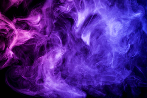Colorful purple smoke on a black isolated background. Background from the smoke of vap