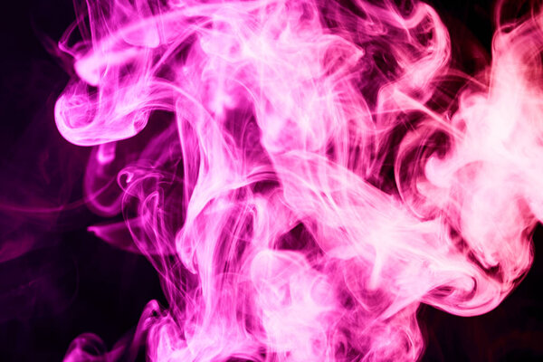 Dense multicolored pink smoke on a black isolated background. Background of smoke vap