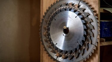 Birçok daire testere bıçakları farklı boyutlarda ahşap arka plan atölye üzerinde metal