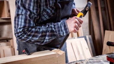 Güçlü marangoz ahşap işleme aracını kullanarak ahşap oyma iş elbiseleri içinde keski, eller yakın marangozluk ve işçilik kavramı,
