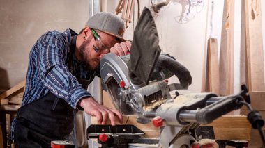 deneyimli marangoz ahşap kesme tahtaları için daire testere kullanarak. Erkek işçi veya elektrikli el aletleri ile handy man inşaat detayları
