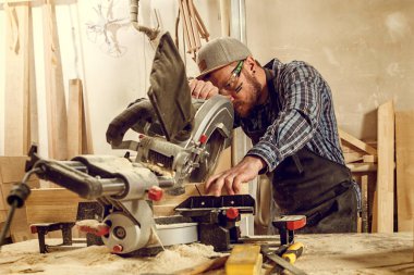 deneyimli marangoz ahşap kesme tahtaları için daire testere kullanarak. Erkek işçi veya elektrikli el aletleri ile handy man inşaat detayları