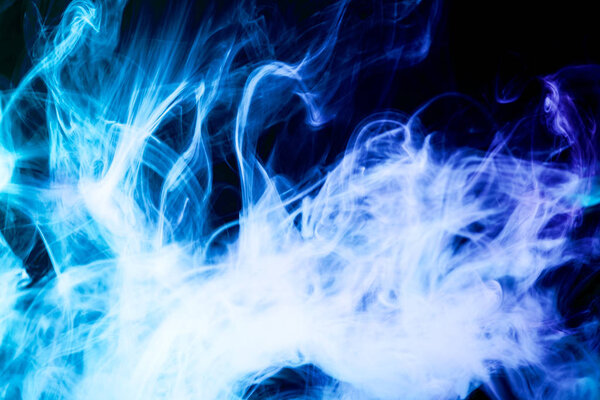Thick colorful blue smoke on a black isolated background. Background from the smoke of vap