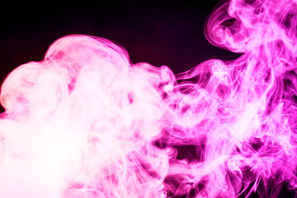 Colorful pink smoke on a black isolated background. Background from the smoke of vap