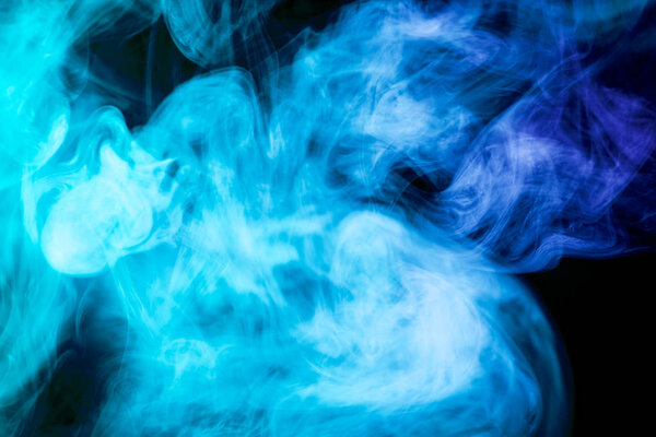Colorful blue smoke on a black isolated background. Background from the smoke of vape