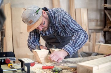 Deneyimli marangoz yakın çalışmalarında giysi ve doğrama atölyesinde çalışan küçük buiness sahibi, kullanarak tablo Çalıştayı ahşap bir barda yapılan bir çekiç ve birçok araç olmasıdır 