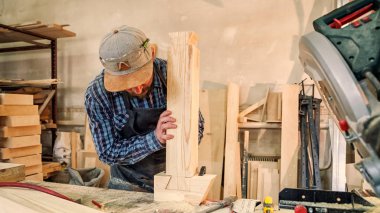 Deneyimli marangoz yakın çalışmalarında giysi ve doğrama atölyesinde çalışan küçük buiness sahibi, kullanarak tablo Çalıştayı ahşap bir barda yapılan bir çekiç ve birçok araç olmasıdır 