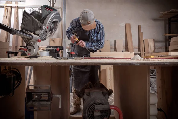Marangoz, tahta kesmek için testere, demir testeresi, inşaat ve onarım, onarım ve inşaat aletlerini testereyle kesmiş.