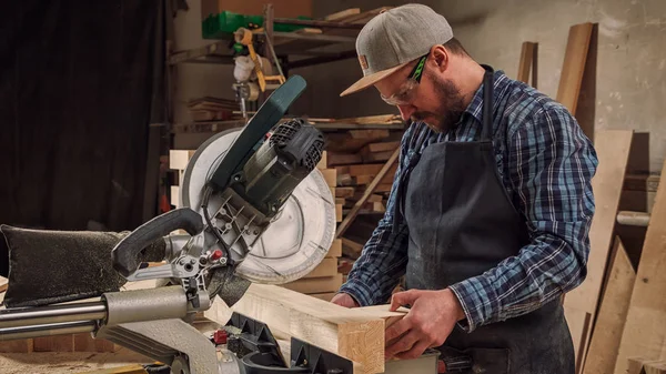 板を切断するための円形ののこぎりで大工の仕事 男はバーを鋸 建設と家庭の改装 修理と建設ツール — ストック写真