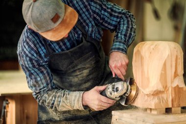 İş elbiseleri ve küçük buiness sahibi doğrama atölyesinde çalışan deneyimli marangoz işler kurulu bir açı ile masaya değirmeni bir çekiç ve birçok araç olduğunu 