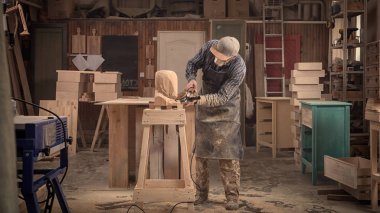 Marangoz, içindeki küçük buiness sahip araçlar, ahşap-mobilya iş için bir sürü atölye bir açı değirmeni kullanarak bir ağaç, bir insan kafası giyim testere iş