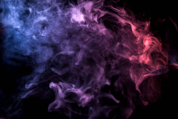 Thick pink, red, blue, purple smoke on a black isolated background. Background from the smoke of vap
