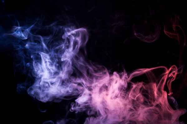 Cloud of blue,pink,purple smoke on a black isolated background. Background from the smoke of vap