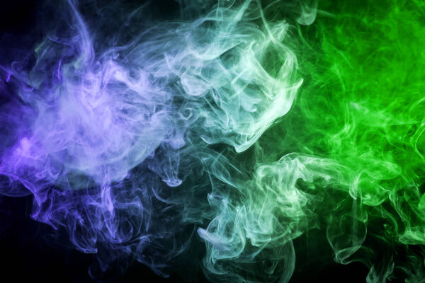 Colorful green and blue smoke on a black isolated background. Background from the smoke of vap