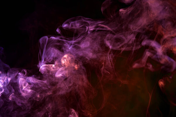 Thick blue, pink and orange smoke on a black isolated background. Background from the smoke of vap