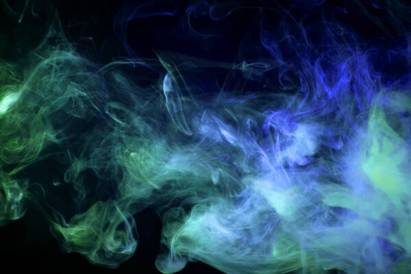 Cloud of green and blue smoke on a black isolated background. Background from the smoke of vap