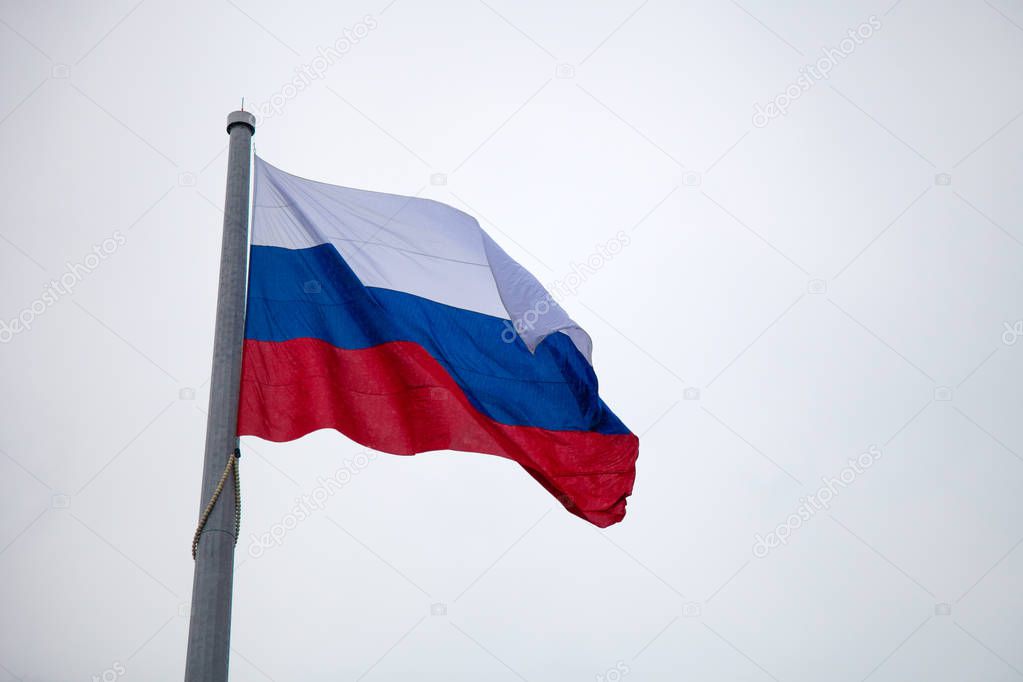 Russian flag on the mast against blue sky