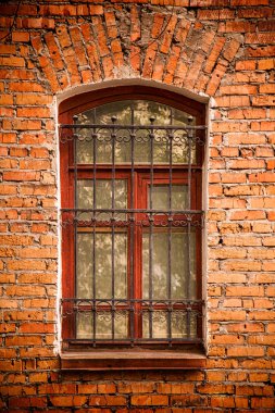 Eski bir kırmızı tuğla ev içinde bölünmüş ızgaraları ile eski bir ahşap pencere Close-up