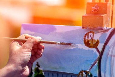 Yakın çekim bir sanatçı bir tuval üzerine bir yaz bir kentsel peyzaj yağlıboya etkinlikler ile boyar.