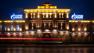 Tomsk, Rusya - 10 Haziran 2018: Gazprom, geceleri vurgulanan çeşitli fenerler ve lambalar yağmur şehir merkezinde tarafından bina eski tuğla