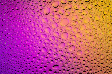 Yakın yukarı bir su damlaları bir mor ve sarı degrade arka plan ile kaplı, damla su - yoğunlaşma.