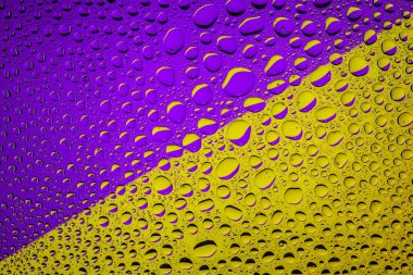 Yakın yukarı bir su damlaları bir mor ve sarı degrade arka plan ile kaplı, damla su - yoğunlaşma.