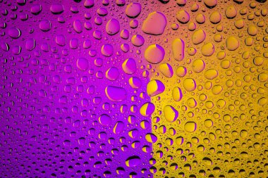 Yakın yukarı bir su damlaları bir mor ve sarı degrade arka plan ile kaplı, damla su - yoğunlaşma.