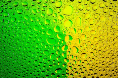 Yakın yukarı bir su damlaları bir yeşil ve sarı degrade arka plan ile kaplı, damla su - yoğunlaşma.