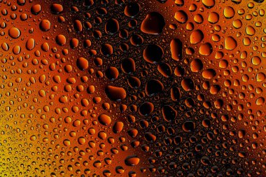 İn yakın bir su damlaları ile kaplı bir sarı, turuncu ve kahverengi degrade arka plan üzerinde damla su - yoğunlaşma.