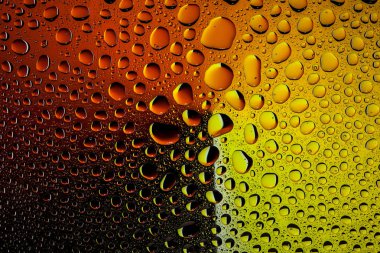 İn yakın bir su damlaları ile kaplı bir sarı, turuncu ve kahverengi degrade arka plan üzerinde damla su - yoğunlaşma.