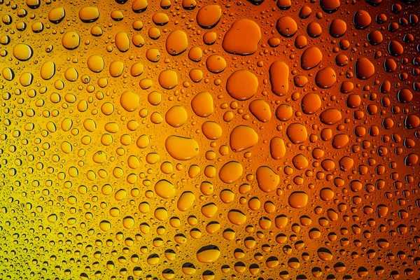 İn yakın bir su damlaları ile kaplı bir sarı, turuncu ve kahverengi degrade arka plan üzerinde damla su - yoğunlaşma.