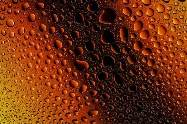 İn yakın bir su damlaları ile kaplı bir sarı, turuncu ve kahverengi degrade arka plan üzerinde damla su - yoğunlaşma.