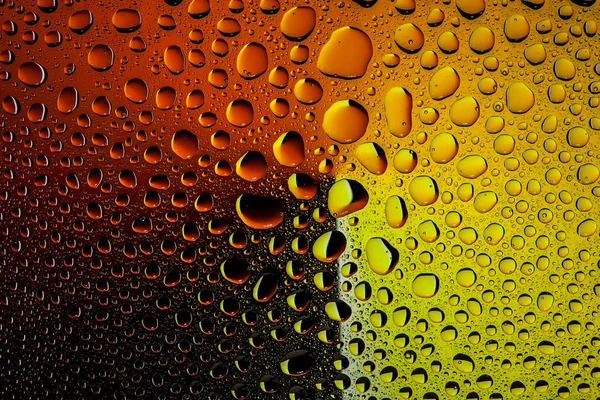 İn yakın bir su damlaları ile kaplı bir sarı, turuncu ve kahverengi degrade arka plan üzerinde damla su - yoğunlaşma.