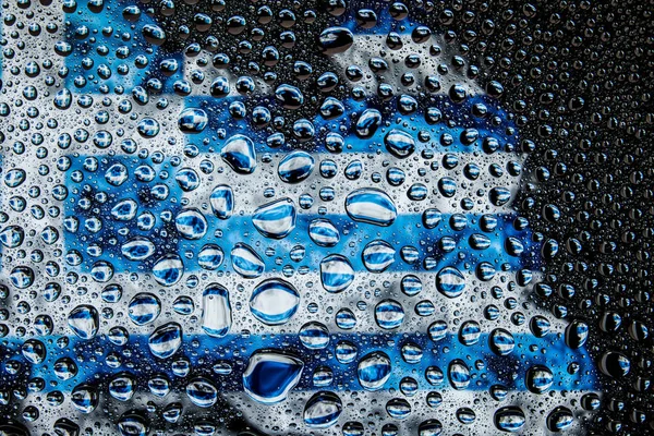 Bir damla su Yunanistan ulusal bayrak izole bir arka plan üzerinde çerçevede bir close-up