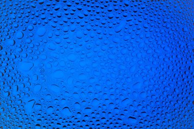 İn yakın bir su damlaları ile kaplı bir mavi degrade arka plan üzerinde damla su - yoğunlaşma.