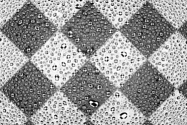 在一个正方形图案的黑色和白色背景上的水滴关闭 覆盖着水滴凝结 — 图库照片
