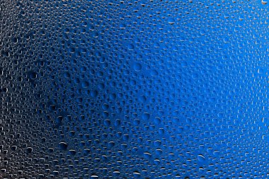 Yakın yukarı bir su damlaları bir siyah ve mavi degrade arka plan ile kaplı, damla su - yoğunlaşma.