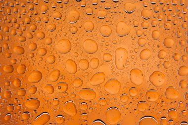 İn yakın bir su damlaları ile kaplı bir turuncu zemin üzerine damla su - yoğunlaşma.