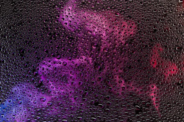 Bir damla su bir mor, pembe ve mavi siyah zemin, degrade arka plan üzerinde yoğunlaşma üzerinde duman karşı Close-up