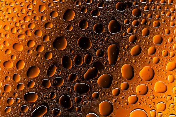 Yakın yukarı bir su damlası bir turuncu ve kahverengi degrade arka plan ile kaplı, damla su - yoğunlaşma.