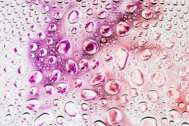 Bir damla su bir mor, pembe ve turuncu beyaz zemin, degrade arka plan üzerinde yoğunlaşma üzerinde duman karşı Close-up