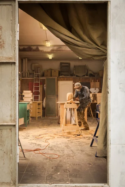 作業服 木工ワーク ショップで働く小さな事業所有者の Arpenter アングル グラインダーと上のボードのプロセス テーブルがハンマーと多くのツール — ストック写真