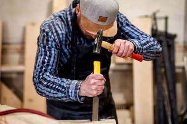 Güçlü marangoz ahşap işleme aracını kullanarak ahşap oyma iş elbiseleri içinde keski, eller yakın marangozluk ve işçilik kavramı,