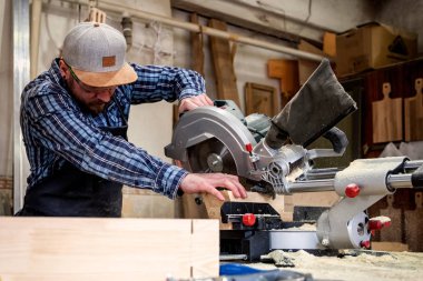 Genç adam Oluşturucusu marangoz kurulu atölye daire testere ile kesme