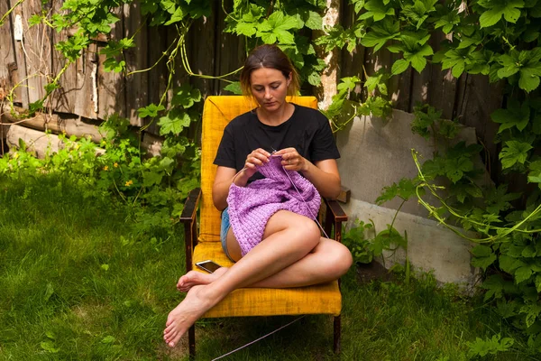 Uma Jovem Mulher Uma Camiseta Preta Calções Ganga Tricota Uma — Fotografia de Stock
