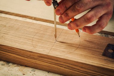 A yakın çekim mobilya yapmak için kalem bir ahşap bar ve metal bir pusula bir erkek marangoz işaretlerinin.