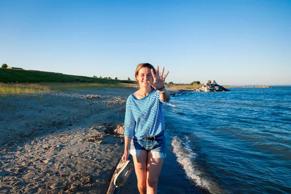 Wesoły Ciemnowłosa Kobieta Dżinsy Paski Shirt Uśmiechy Spacery Wzdłuż Plaży — Zdjęcie stockowe