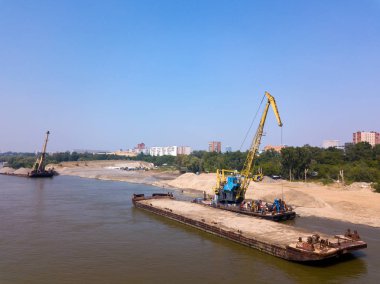 Havadan görünümü: mavna kargo ve inşaat ile vinç arka planda Nehri'ndeki modern bir şehir ve bir park. Kargo gemisi Nehri üzerinde.