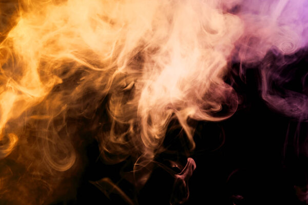 Thick colorful smoke of pink, orange on a black isolated background. Background from the smoke of vap