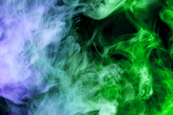 Blue and green smoke on a black isolated background. Background from the smoke of vape